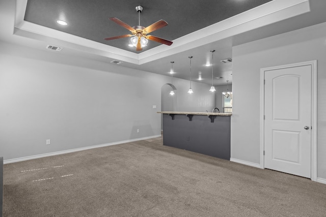 2208 Boise Dr, Odessa, TX 79762 - carpeted empty room featuring a tray ceiling, ceiling fan, arched walkways, and recessed lighting