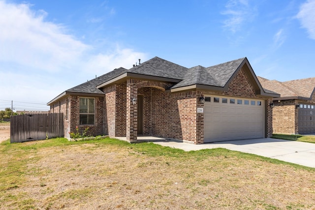 2208 Boise Dr, Odessa, TX 79762 - view of front facade with brick siding, a garage, driveway, and a shingled roof