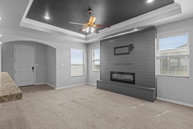 2208 Boise Dr, Odessa, TX 79762 - unfurnished living room featuring a raised ceiling, light carpet, ceiling fan, recessed lighting, and arched walkways