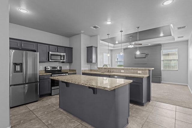 2208 Boise Dr, Odessa, TX 79762 - kitchen with appliances with stainless steel finishes, a raised ceiling, a peninsula, light tile patterned floors, and recessed lighting