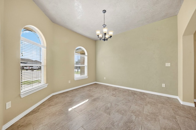 14 Da Vinci Ct, Odessa, TX 79765 - empty room featuring plenty of natural light, a chandelier, arched walkways, a textured ceiling, and baseboards
