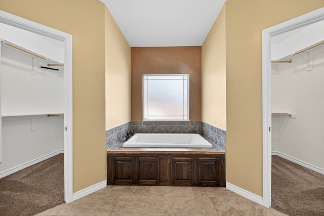 14 Da Vinci Ct, Odessa, TX 79765 - bathroom featuring a bath, a walk in closet, and baseboards