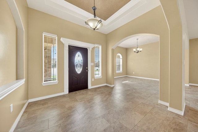 14 Da Vinci Ct, Odessa, TX 79765 - entryway featuring arched walkways, baseboards, a chandelier, a tray ceiling, and stone finish flooring