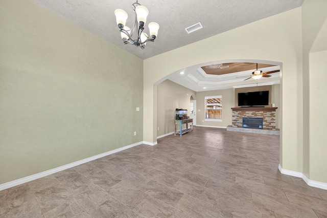 14 Da Vinci Ct, Odessa, TX 79765 - unfurnished living room with arched walkways, a ceiling fan, a chandelier, a stone fireplace, and baseboards
