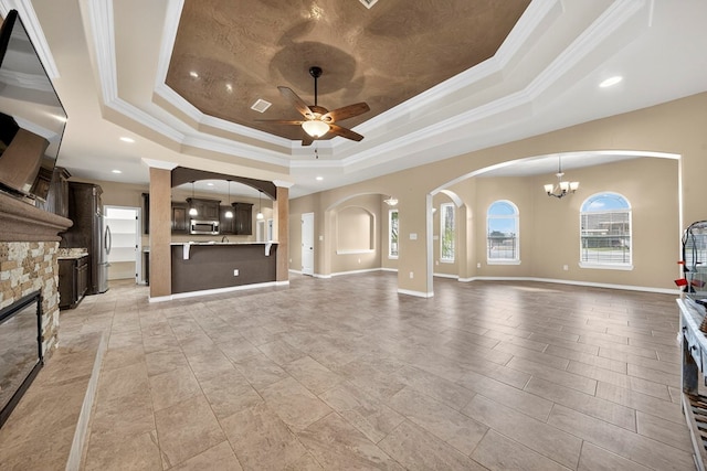 14 Da Vinci Ct, Odessa, TX 79765 - unfurnished living room featuring a tray ceiling, crown molding, ceiling fan, a chandelier, and a fireplace