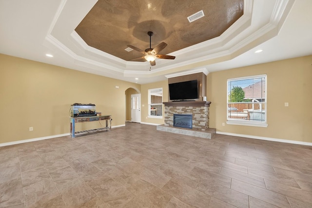 14 Da Vinci Ct, Odessa, TX 79765 - unfurnished living room with a raised ceiling, ornamental molding, arched walkways, ceiling fan, and a stone fireplace