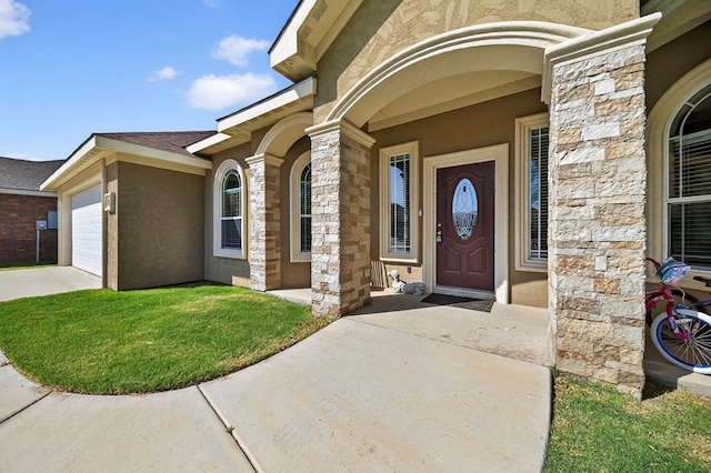 14 Da Vinci Ct, Odessa, TX 79765 - doorway to property featuring a garage, stone siding, concrete driveway, stucco siding, and a yard