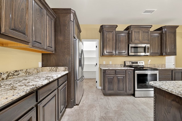14 Da Vinci Ct, Odessa, TX 79765 - kitchen with appliances with stainless steel finishes, dark brown cabinetry, and light stone counters
