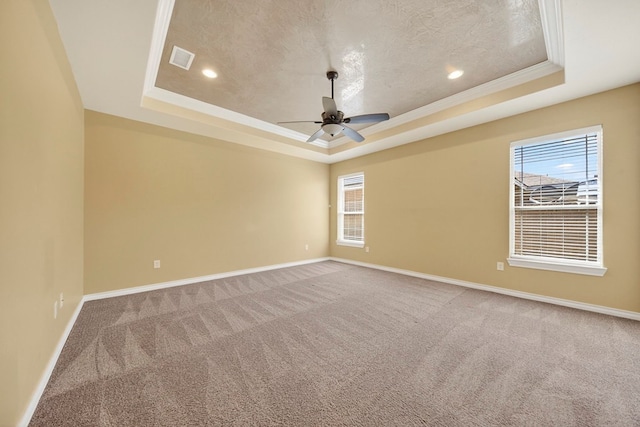 14 Da Vinci Ct, Odessa, TX 79765 - carpeted spare room featuring a tray ceiling, healthy amount of natural light, baseboards, crown molding, and a textured ceiling