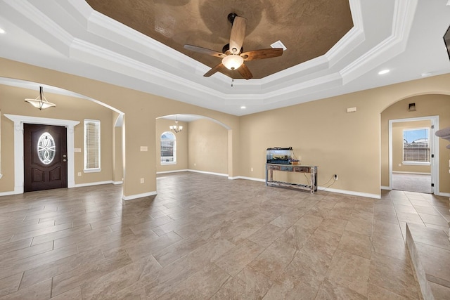 14 Da Vinci Ct, Odessa, TX 79765 - unfurnished living room featuring a raised ceiling, crown molding, arched walkways, ceiling fan, and recessed lighting