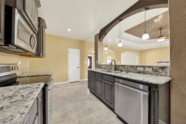 14 Da Vinci Ct, Odessa, TX 79765 - kitchen with stainless steel appliances, a sink, a ceiling fan, baseboards, and hanging light fixtures