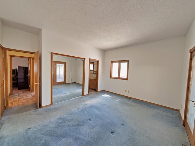 101 Hereford Dr, Fort Davis, TX 79734 - unfurnished bedroom with carpet, multiple windows, freestanding refrigerator, a textured ceiling, and a closet