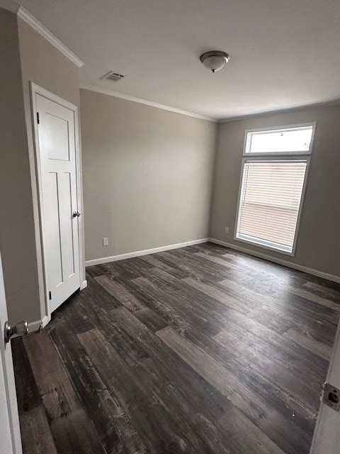 610 Magnolia, Kermit, TX 79745 - empty room featuring ornamental molding and dark wood-type flooring
