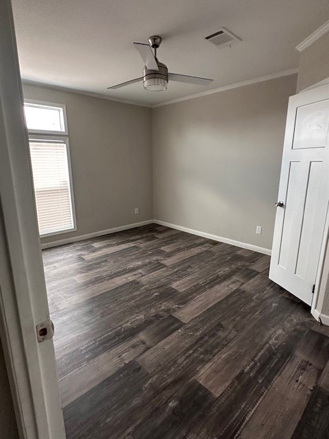 610 Magnolia, Kermit, TX 79745 - spare room with a ceiling fan, crown molding, and dark wood finished floors