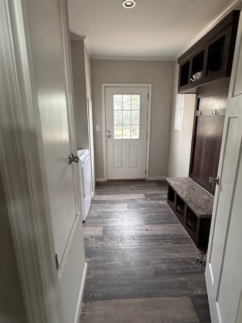 610 Magnolia, Kermit, TX 79745 - mudroom featuring washing machine and dryer, dark wood-type flooring, and ornamental molding
