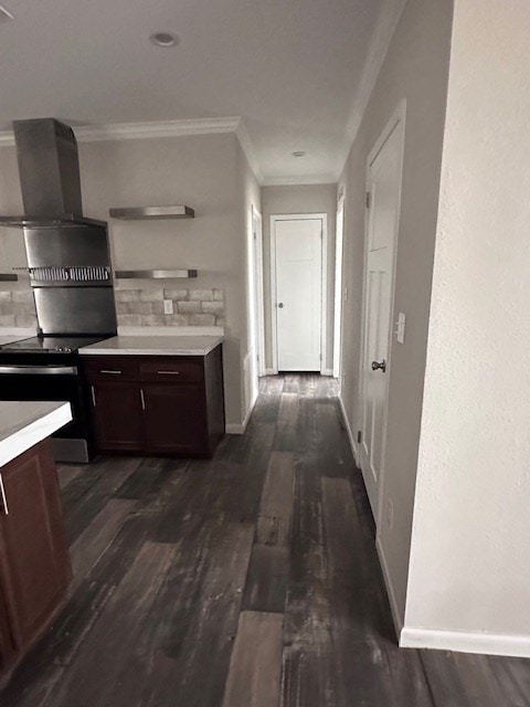 610 Magnolia, Kermit, TX 79745 - kitchen featuring decorative backsplash, dark brown cabinets, dark wood-style floors, wall chimney exhaust hood, and crown molding