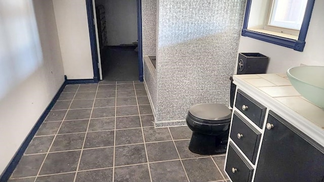 1000 N 12th St, Wink, TX 79789 - bathroom featuring tile patterned flooring, toilet, vanity, and a tub to relax in