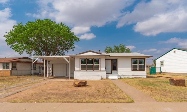 view of front of home featuring a garage, an attached carport, driveway, and brick siding