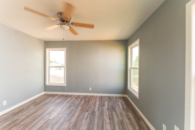 unfurnished room featuring baseboards, ceiling fan, and wood finished floors