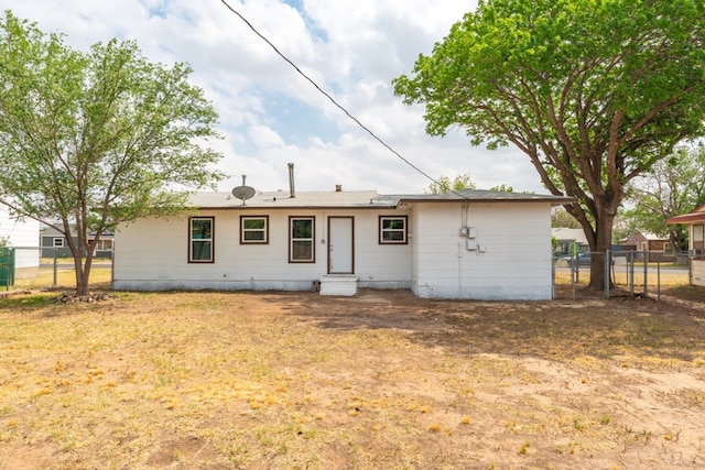 back of house featuring fence, a gate, and entry steps