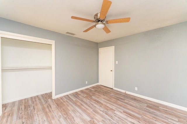 unfurnished bedroom with visible vents, baseboards, wood finished floors, and a closet