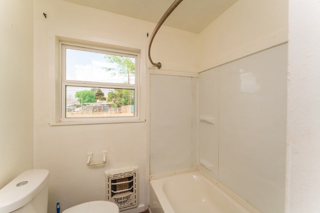 bathroom featuring toilet, heating unit, and washtub / shower combination