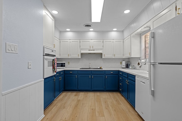 3700 Fairmont Dr, Odessa, TX 79762 - kitchen with white appliances, blue cabinetry, light wood-style flooring, white cabinets, and a wainscoted wall