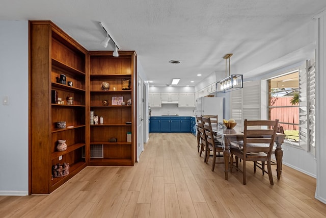 3700 Fairmont Dr, Odessa, TX 79762 - dining area with light wood-type flooring, track lighting, and a textured ceiling