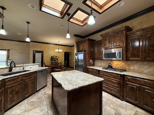 7802 Sienna Dr, Odessa, TX 79765 - kitchen featuring appliances with stainless steel finishes, ornamental molding, decorative backsplash, a kitchen island, and hanging light fixtures