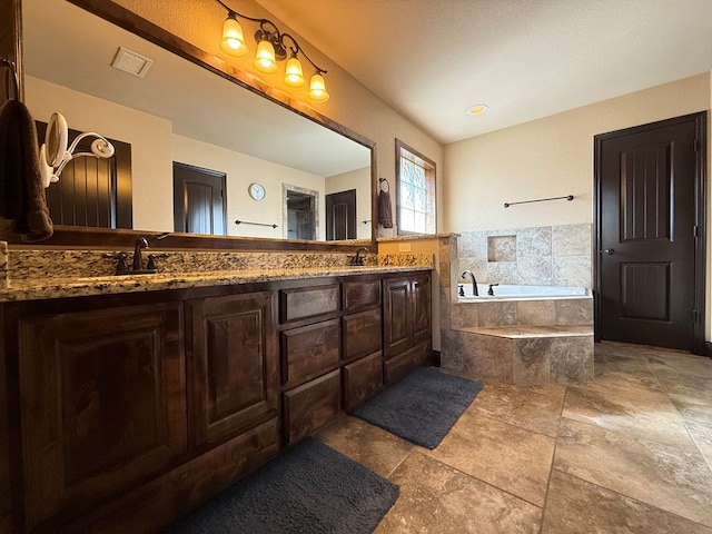 7802 Sienna Dr, Odessa, TX 79765 - full bathroom with double vanity, a garden tub, and stone finish floors