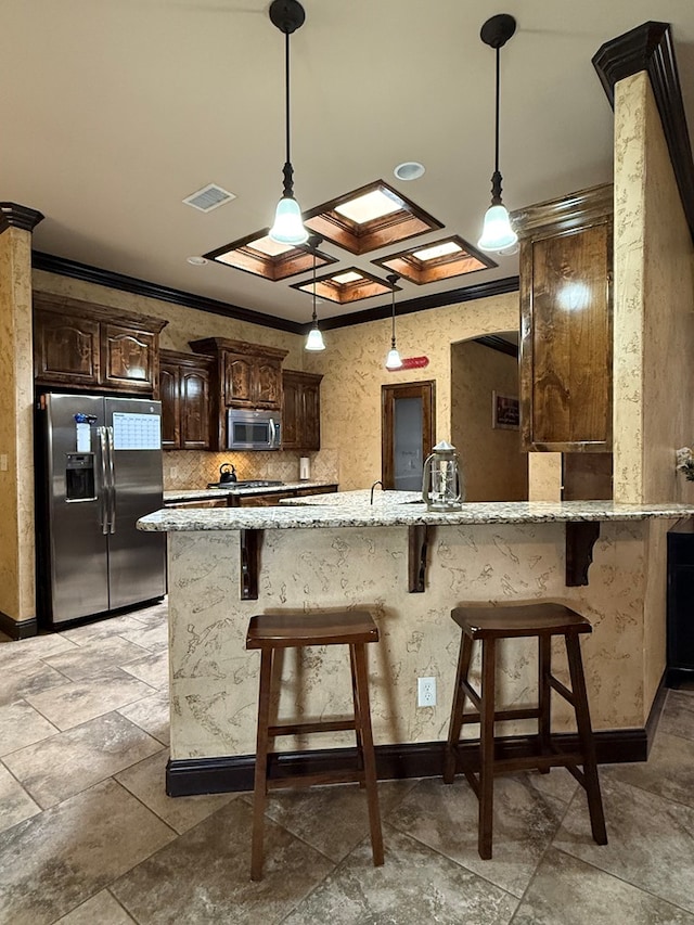 7802 Sienna Dr, Odessa, TX 79765 - kitchen with stainless steel appliances, dark brown cabinetry, light stone counters, crown molding, and a breakfast bar