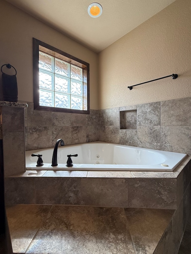 7802 Sienna Dr, Odessa, TX 79765 - bathroom featuring a tub with jets and a textured wall