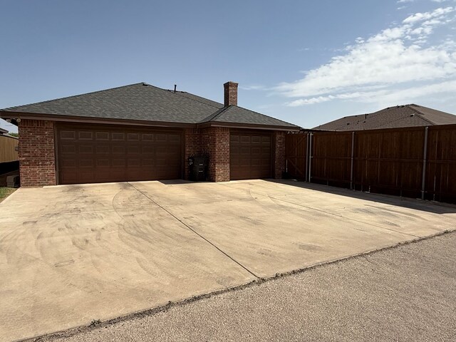 7802 Sienna Dr, Odessa, TX 79765 - view of front of home with a garage, brick siding, concrete driveway, and a chimney