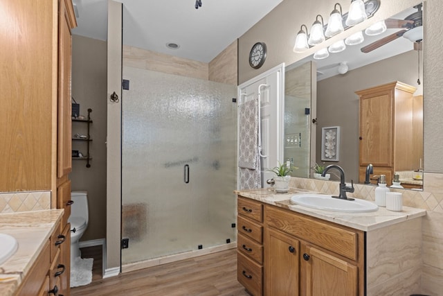 3960 Rabb St, Odessa, TX 79762 - full bath featuring vanity, a stall shower, wood finished floors, and decorative backsplash