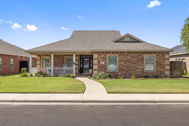 3960 Rabb St, Odessa, TX 79762 - view of front of house with covered porch, brick siding, a front lawn, and roof with shingles