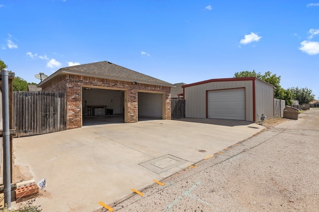 3960 Rabb St, Odessa, TX 79762 - view of front facade featuring brick siding, an outdoor structure, a garage, and roof with shingles
