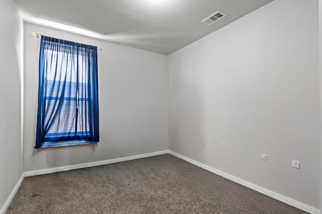 spare room featuring carpet flooring and baseboards