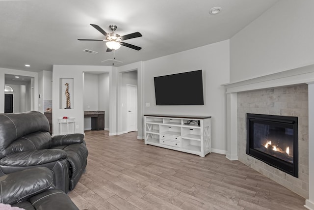 living room featuring wood finished floors, ceiling fan, baseboards, a glass covered fireplace, and recessed lighting
