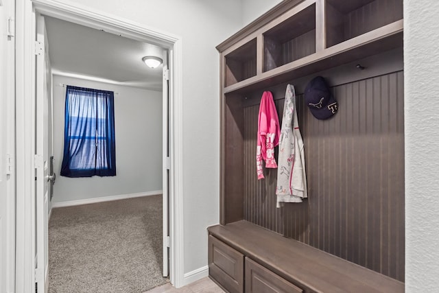 mudroom with light carpet and baseboards