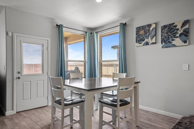 dining room with light wood finished floors and baseboards