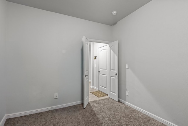empty room featuring carpet floors and baseboards