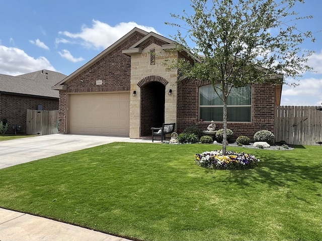 french provincial home featuring driveway, a front yard, fence, and a garage