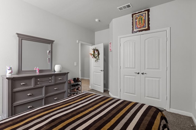 carpeted bedroom featuring a closet and baseboards
