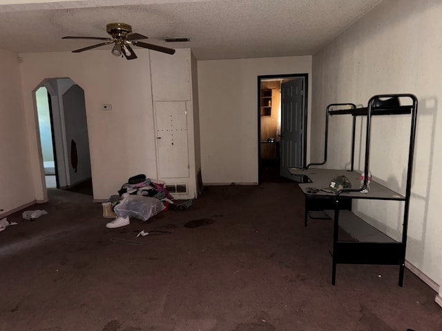 1140 Clifford St, Odessa, TX 79763 - unfurnished living room featuring arched walkways, a ceiling fan, and a textured ceiling