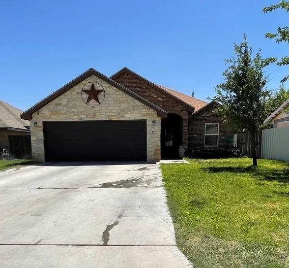 ranch-style house with a garage and a front yard