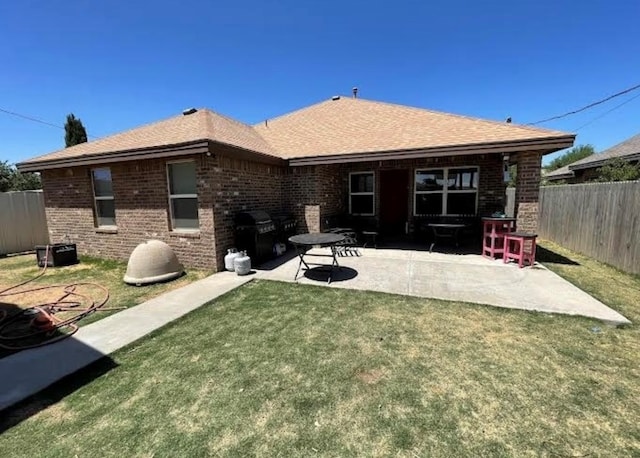 rear view of property with a yard and a patio