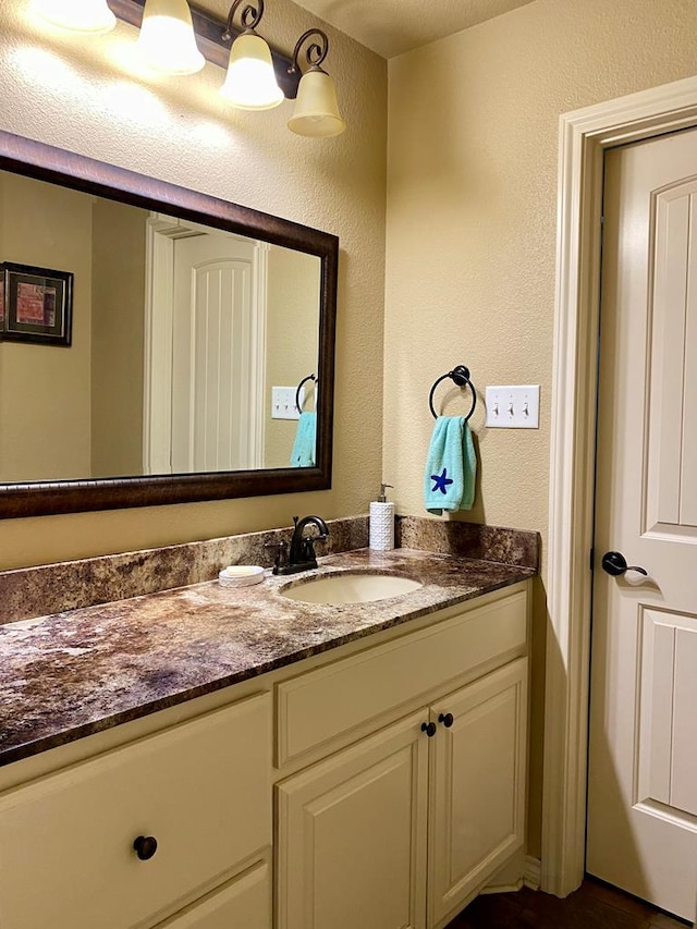 bathroom featuring vanity and a textured wall