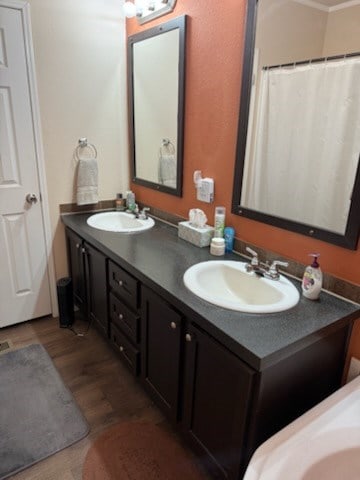 bathroom featuring double vanity, a sink, and wood finished floors