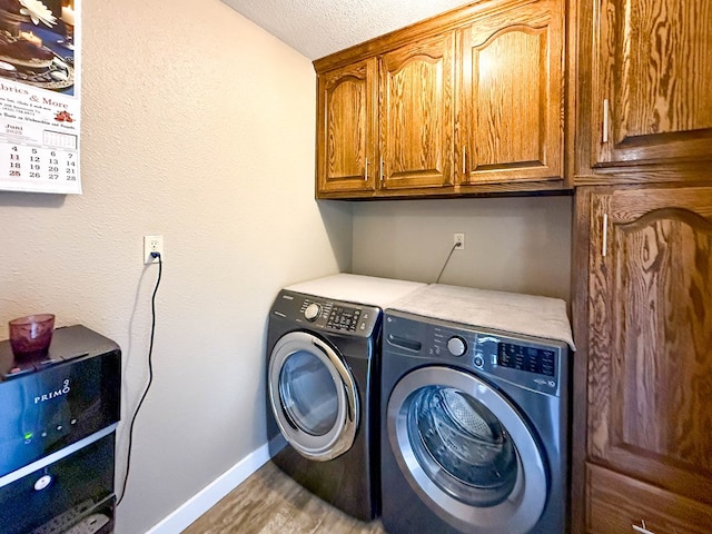 305 County Rd 306, Seminole, TX 79360 - laundry room featuring cabinet space, separate washer and dryer, wood finished floors, and a textured ceiling