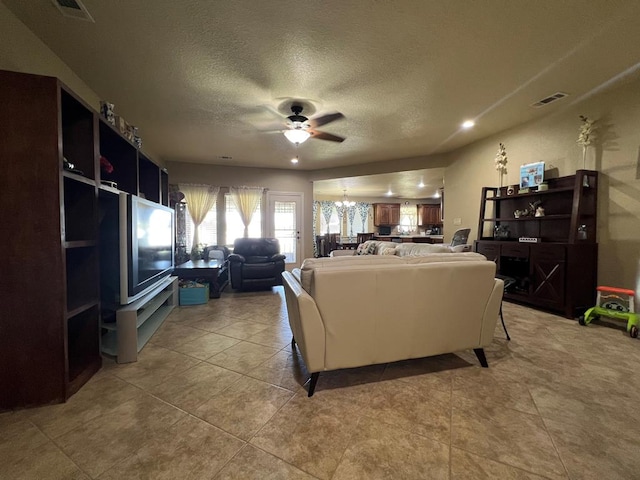3717 S County Rd 1314, Odessa, TX 79765 - living area featuring a ceiling fan, a textured ceiling, a chandelier, and light tile patterned floors
